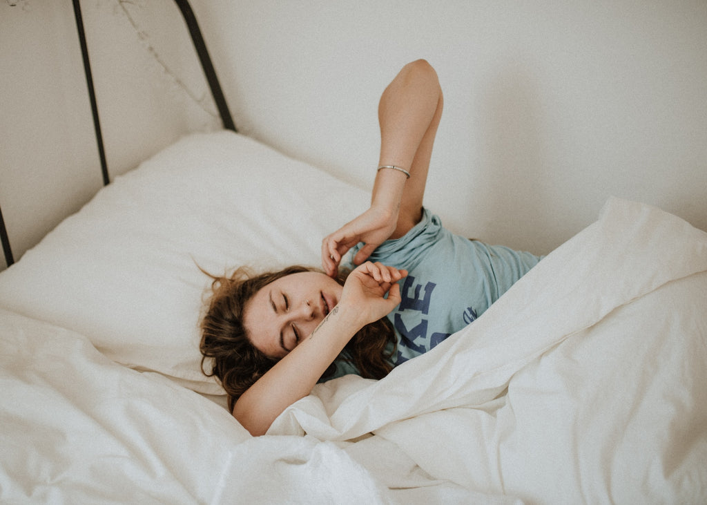 A woman struggling to get out of bed