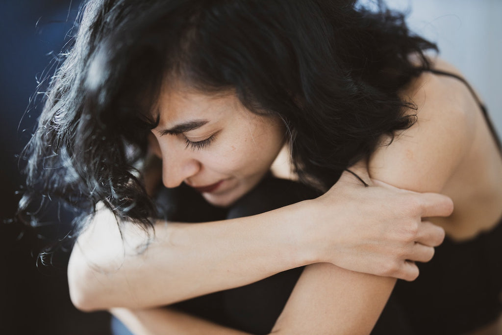 A woman with anxiety sitting with her head down